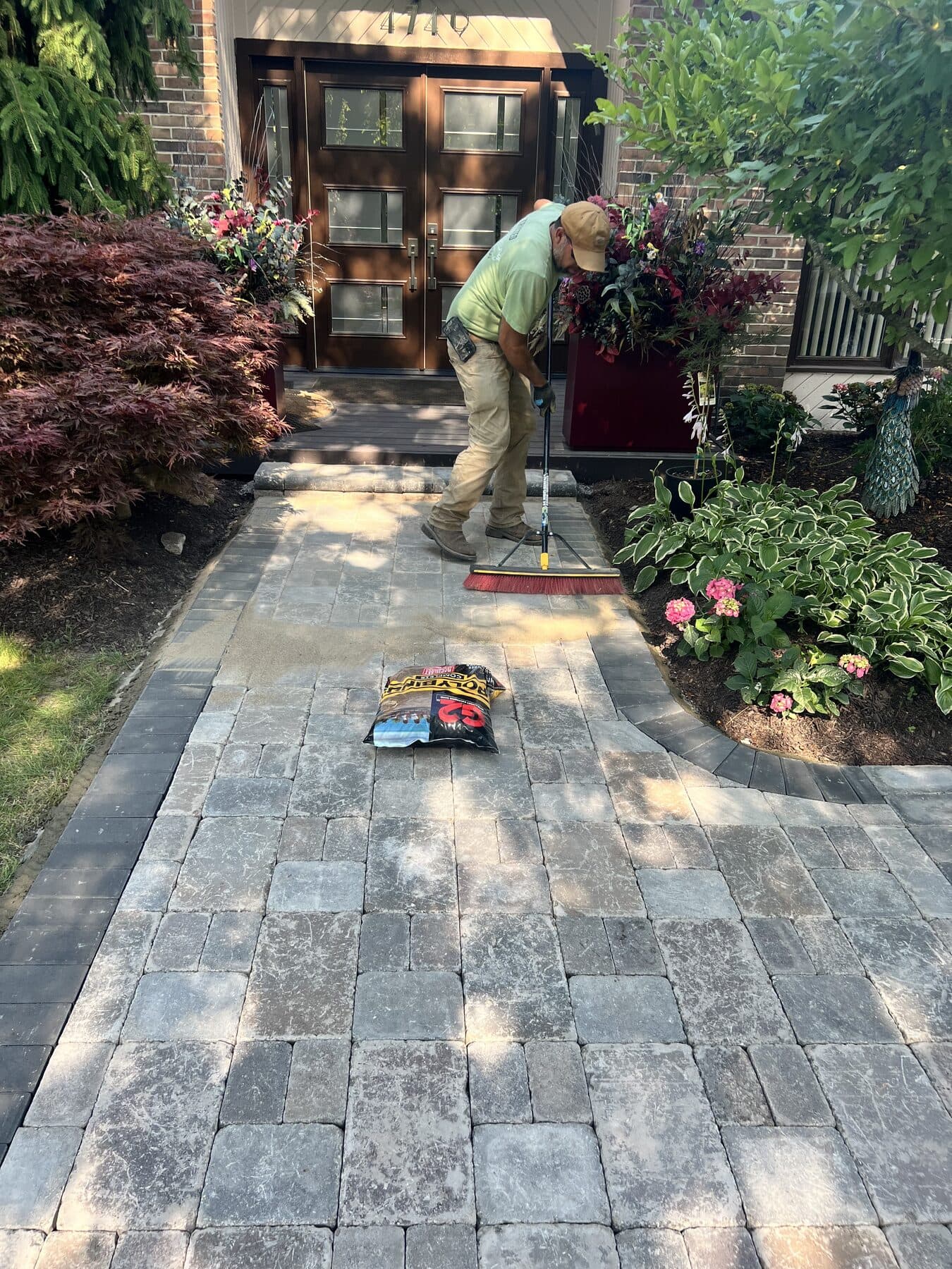 Finished paver walkway, polymeric sand being swept in